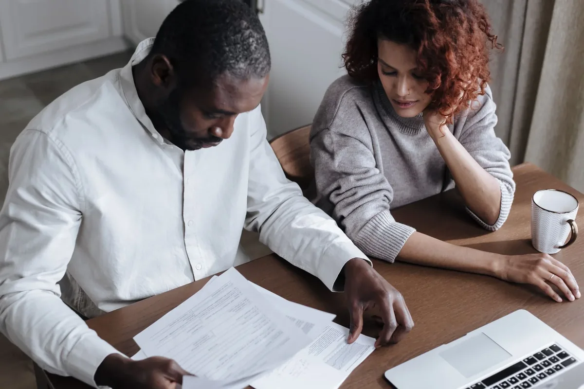Two people sitting together at a table reviewing household documents